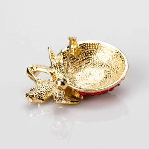 Gouden kerstbroche achteraanzicht met hamerpatroon textuur en veilige speldsluiting