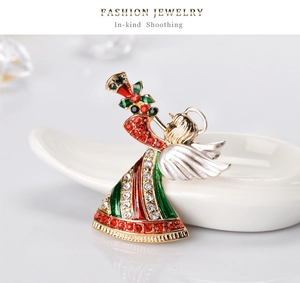 Détail d'une broche de Noël ange avec émail rouge vert et strass étincelants