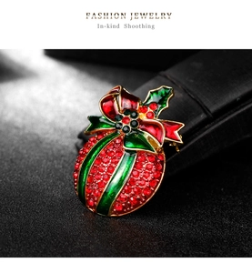 Detailed view of Christmas brooch with red crystals and a festive green enamel bow