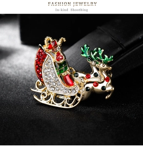 Détail de la broche traîneau de renne de Noël avec strass rouges et verts sur métal doré