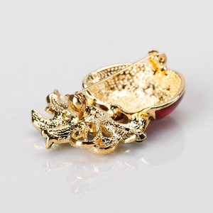 Achterkant van gouden kerstbroche met metalen textuur en veilige speldsluiting