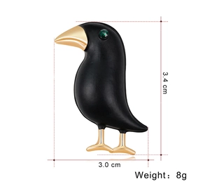 Detailed view showing dimensions of black crow brooch with green gem eye and gold accents