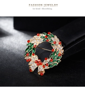 Macro shot of green enamel Christmas wreath brooch with sparkling red and white crystals