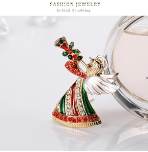 Détail d'une broche ange de Noël avec émail coloré et strass brillants sur socle doré