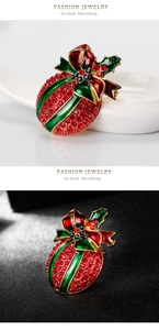 Detail of Christmas holly brooch with red rhinestones and green enamel on dual backgrounds