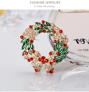 Close-up of Christmas wreath brooch with red and white rhinestones and green enamel