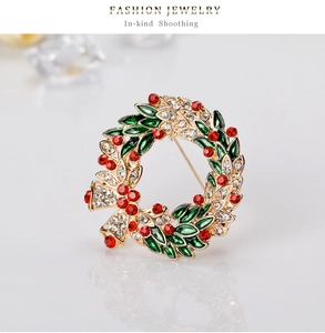 Detail of Christmas wreath brooch with red rhinestones and green enamel leaf finish