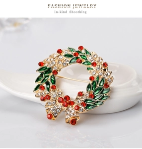 Detail of Christmas wreath brooch with green enamel leaves, red crystals and bells