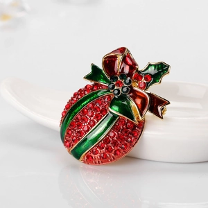 Elegant Christmas brooch with red rhinestones and green enamel bow on a white tray