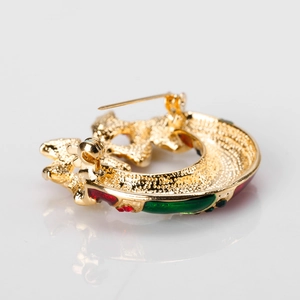 Macro-opname van de kerstbroche achterkant met vergulding en emaille afwerking details