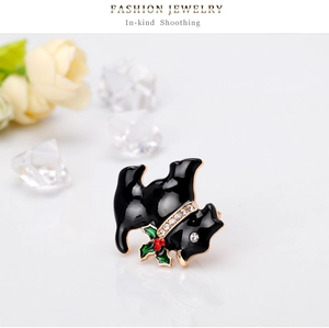 Détail d'une broche Terrier écossais en émail noir avec collier en cristal et houx de Noël