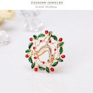 Détail d'une broche couronne de Noël avec feuilles d'émail vert et renne doré