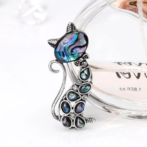 Macro d'une broche chat mignonne avec coquille d'abalone et nœud en cristal brillant