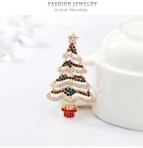 Dettaglio della spilla a forma di albero di Natale con strass su ceramica