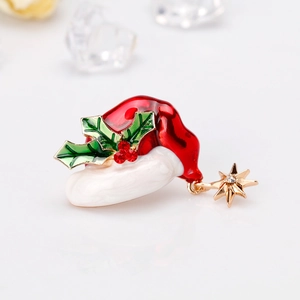 Details einer Weihnachtsmützen-Brosche mit Emaille-Stechpalmen und Sternanhänger