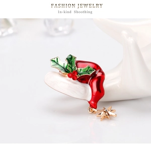 Detail of Christmas hat brooch with red enamel, holly leaves and hanging gold star