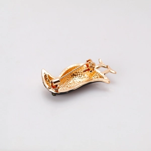 Golden crow bird brooch back view with textured alloy finish and safety pin closure