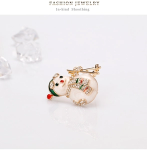 Detail shot of skiing snowman brooch with white enamel, rhinestones and golden ski poles
