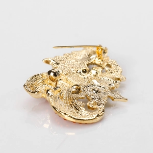 Achteraanzicht van gouden kerstlaars broche met getextureerde afwerking en speld