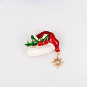 Detailed shot of Christmas hat brooch with enamel leaves and sparkling star pendant