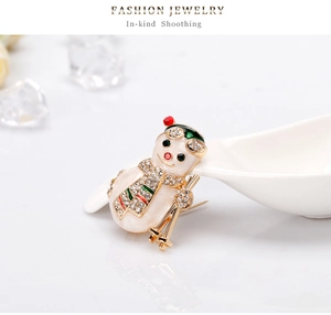 Macro shot of a Christmas snowman brooch with rhinestones and gold plating details