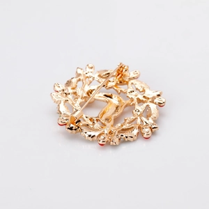 Vue arrière d'une broche couronne de Noël en alliage doré avec fermoir à épingle robuste