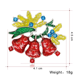 Makroaufnahme einer farbenfrohen Weihnachtsglockenbrosche mit rotem Emaille und Strass