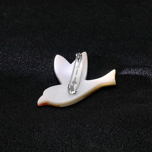 Détail de l'arrière de la broche oiseau avec épingle de sûreté et texture nacrée
