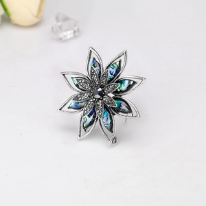 Dettaglio di spilla vintage a fiore con petali in abalone e finitura in marcasite