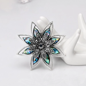 Dettaglio di spilla a fiore ottagonale argento con intarsio in conchiglia e cristallo