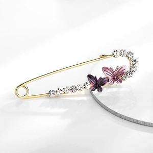 Dettaglio della spilla a farfalla con cristalli viola e smalto su metallo dorato