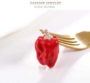 Vue macro d'une broche piment rouge tendance avec cristaux sur une fourchette dorée