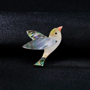 Broche oiseau en nacre d'abalone naturelle avec des reflets irisés et design élégant