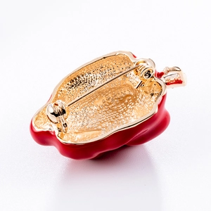 Vue avant et arrière d'une broche piment rouge avec émail brillant et base dorée