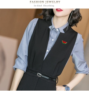 Detailed view of enamel watermelon brooch pinned on a grey shirt and black suit vest