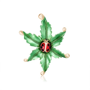 Vue détaillée d'une broche feuille verte avec coccinelle rouge en émail brillant