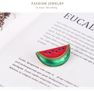 Detail shot of watermelon brooch with red and green enamel and small black rhinestones
