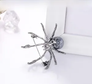 Detailed view of spider brooch with large grey pearl and vintage silver alloy texture