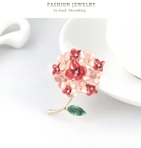 Detailed macro view of pink enamel flower brooch with small crystals and golden branches