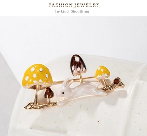 Detailed close-up of rabbit and mushroom enamel brooch with golden alloy accents