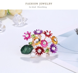Close-up of alloy daisy brooch with colorful enamel flowers, rhinestones and teardrop gem