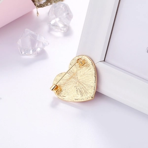 Detail view of the gold heartbeat brooch back featuring a secure safety pin fastener