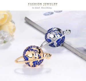 Detailed close-up of gold globe planet ring with blue enamel and metallic orbital ring