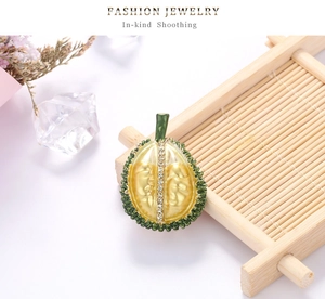 Detailed view of realistic green and yellow durian brooch with white rhinestones