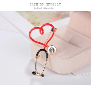 Détail macro de la broche cœur stéthoscope avec émail rouge et zircon sur une boîte à bijoux