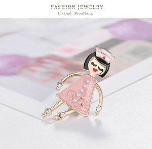 Détail d'une broche infirmière en émail rose avec des accents de strass étincelants