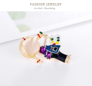 Detail of artistic girl brooch with purple dress holding a colorful palette accessory