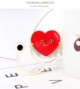 Détail macro d'une broche stéthoscope cœur rouge avec sourire et bords dorés