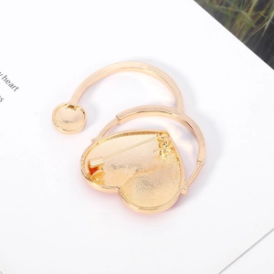 Detailed back view of gold heart brooch with needle buckle closure and metallic texture