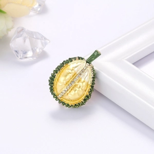Fashionable green durian brooch pin with yellow enamel and white crystals on white backdrop